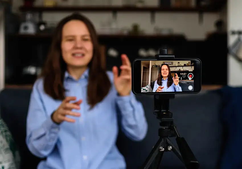 A woman filming herself with a phone.
