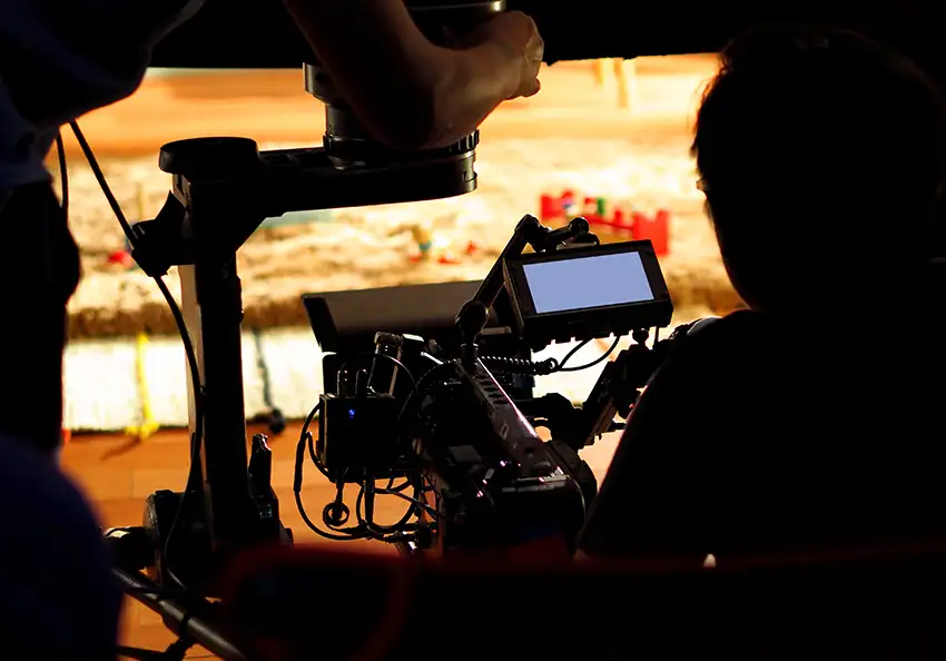 A cinematographer prepares the camera for filming.